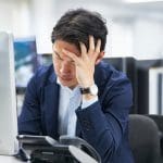 5 Reasons Endpoint Security Alone Won’t Stop Ransomware 1 Endpoint security concerns indicated by a business professional appearing distressed in front of a computer.